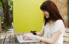 Woman working on a laptop and smiling